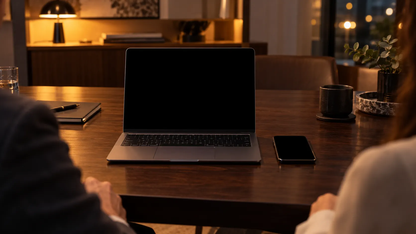 Reunião com o cliente: notebook aberto mostrando a proposta e um celular sobre a mesa